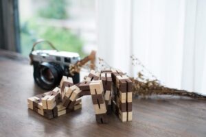 Image displays the puzzle Kibble Cube unwound as a table decoration placed next to a camera to add a rustic feel.